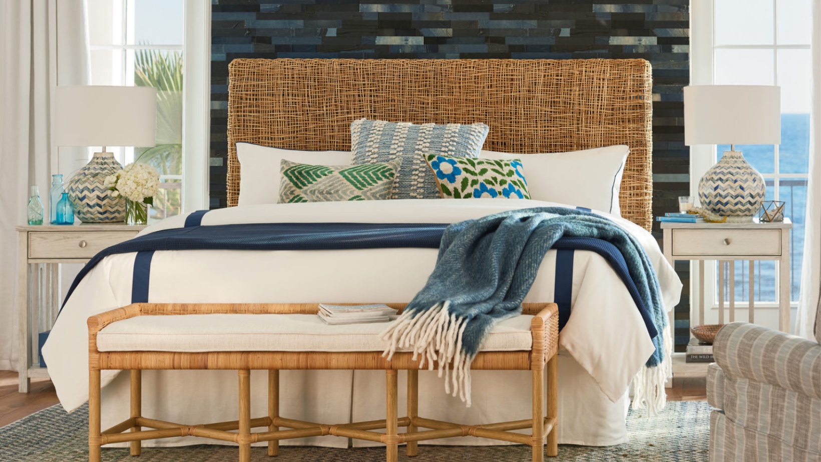 Serene bedroom with a woven seagrass headboard, natural materials and ocean views, organic luxury design by Landry Designs