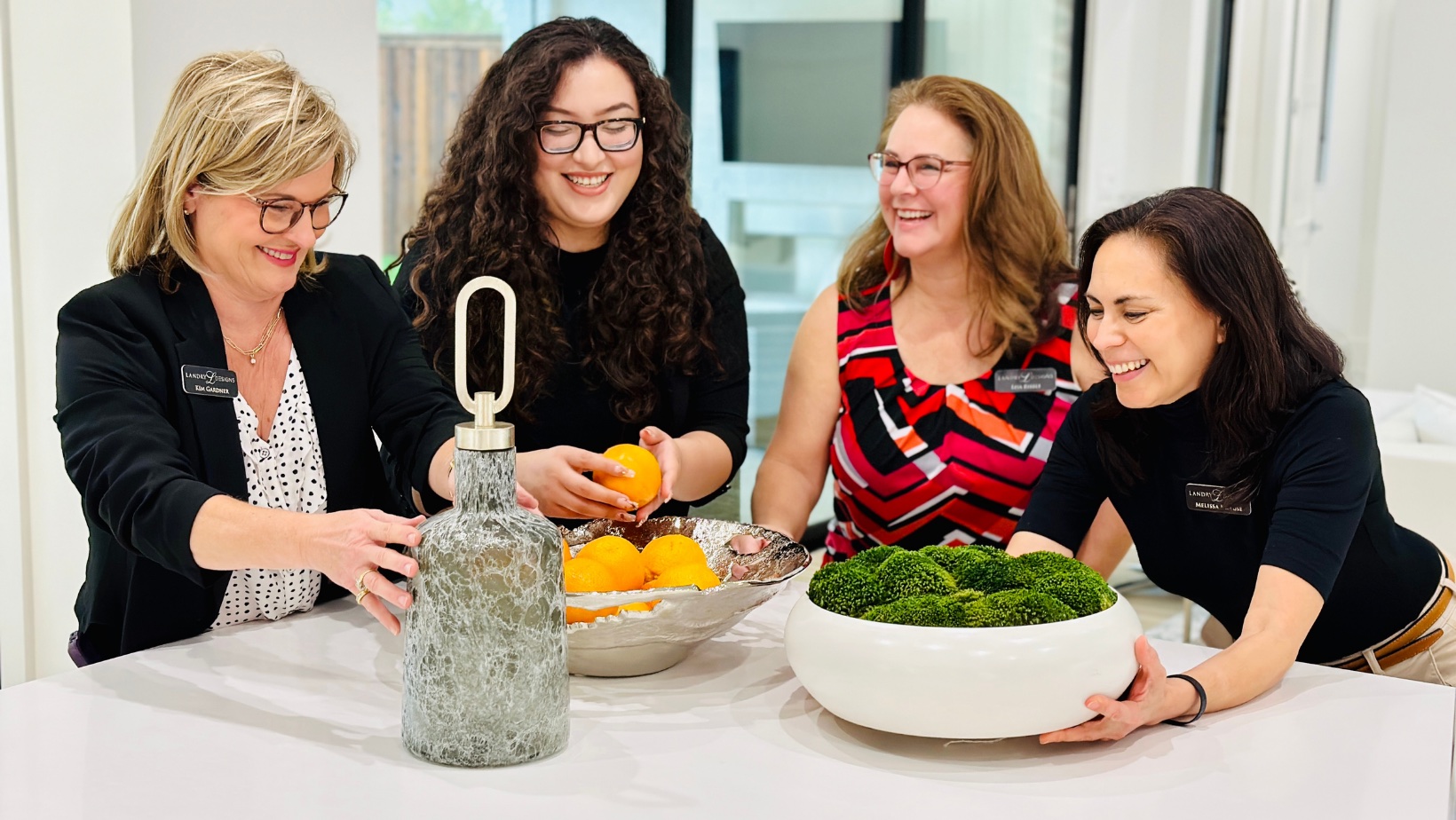 The Landry Designs team arranging natural decor elements in a bright studio
