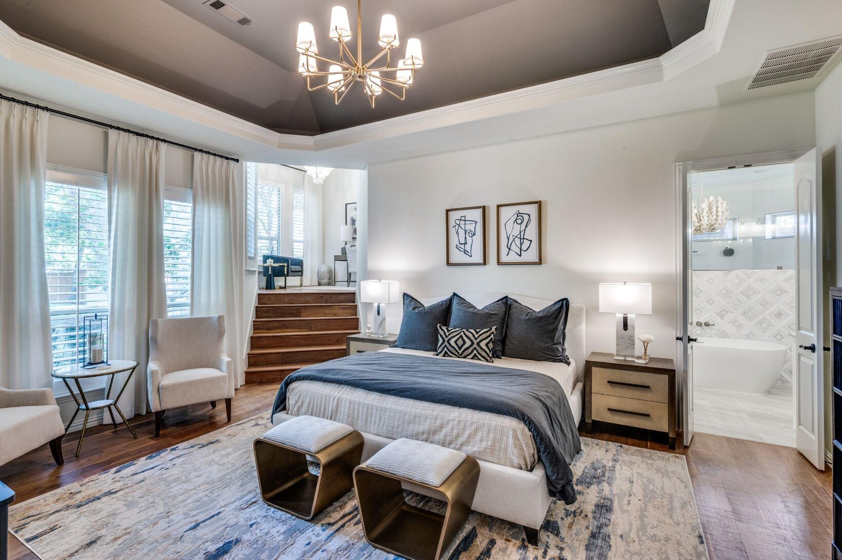 Master suite with a deep matte tray ceiling and muted blue-gray walls showing low-sheen paint finishes by Landry Designs
