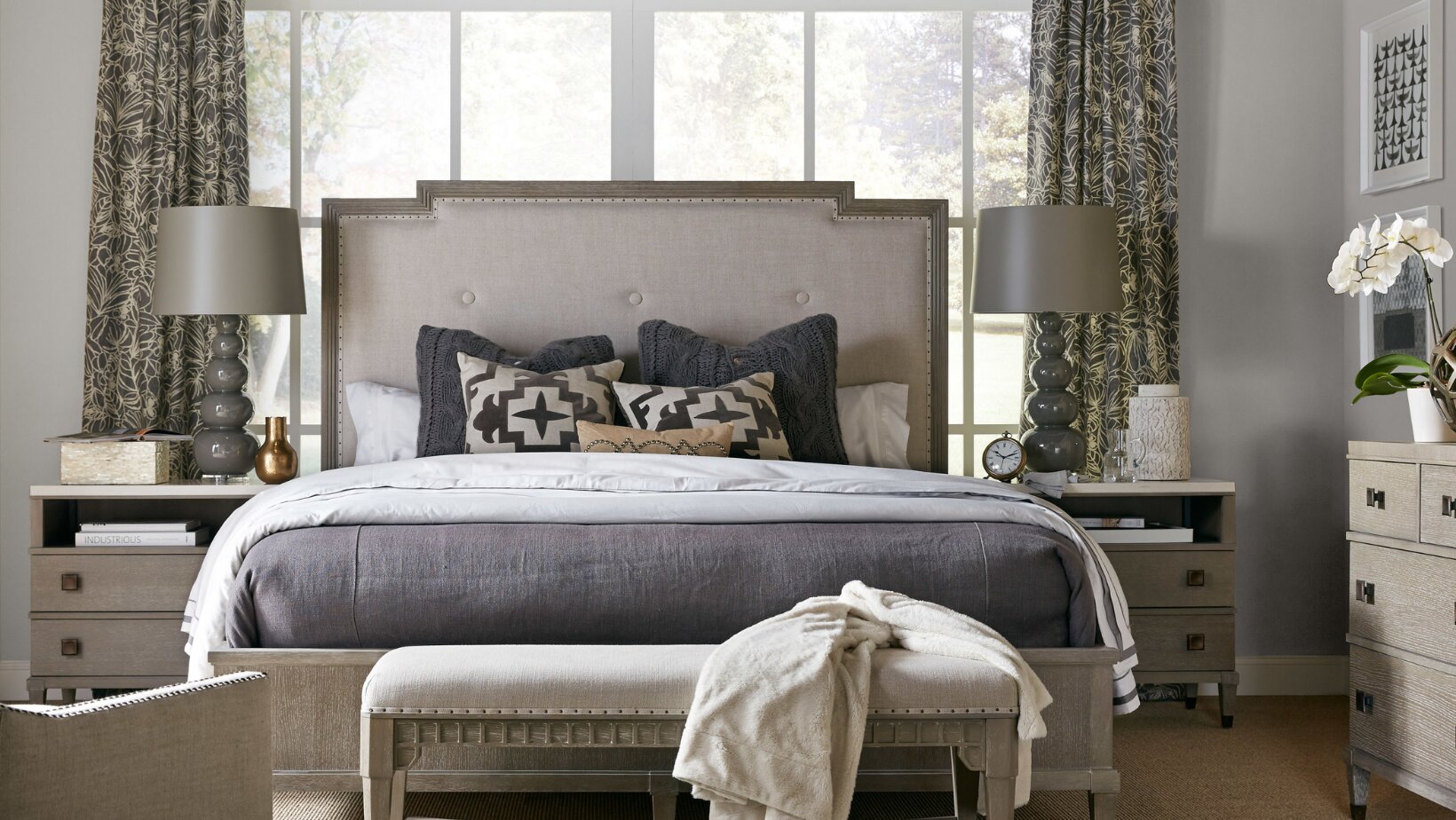 Serene master bedroom in muted slate-blue and soft gray tones with a symmetrical, balanced layout by Landry Designs